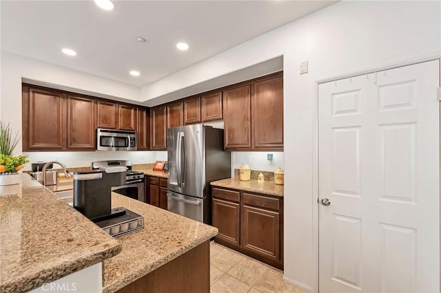 31170 Strawberry Tree Ln Unit 67, Temecula, CA 92592 - kitchen featuring stainless steel appliances, light stone counters, recessed lighting, light tile patterned floors, and dark brown cabinetry