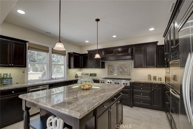 62 Gentry, Irvine, CA 92620 - kitchen featuring stainless steel appliances, a center island, light stone counters, decorative light fixtures, and recessed lighting