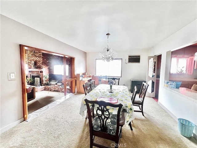407 S Northwood Ave, Compton, CA 90220 - dining area featuring light colored carpet, a chandelier, a brick fireplace, and an AC wall unit