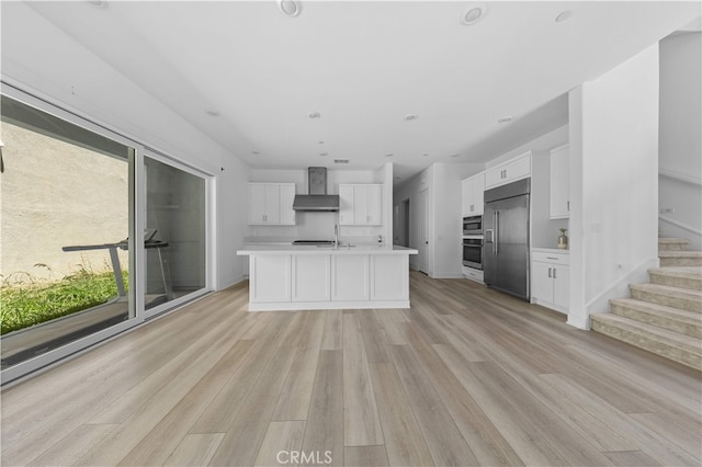 27216 W Coyote Bush Ct, Valencia, CA 91355 - kitchen with built in fridge, wall chimney exhaust hood, plenty of natural light, and light countertops