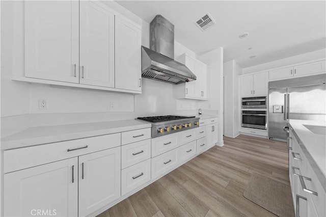 27216 W Coyote Bush Ct, Valencia, CA 91355 - kitchen featuring wall chimney range hood, stainless steel appliances, white cabinetry, and light countertops