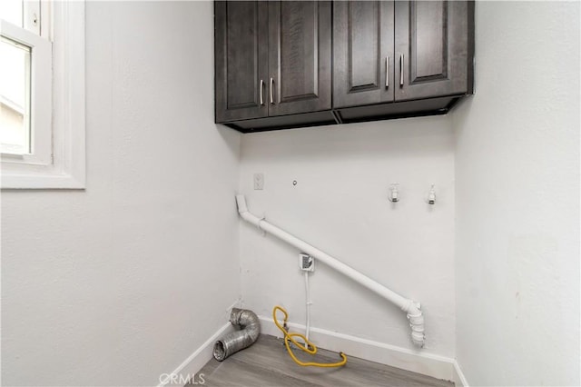 2058 N Pico Ave, San Bernardino, CA 92411 - washroom featuring cabinet space, hookup for a gas dryer, and wood finished floors