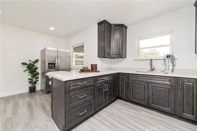 2058 N Pico Ave, San Bernardino, CA 92411 - kitchen with stainless steel fridge, light countertops, a peninsula, plenty of natural light, and recessed lighting