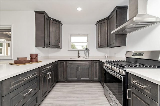 2058 N Pico Ave, San Bernardino, CA 92411 - kitchen featuring gas range, wall chimney range hood, light countertops, recessed lighting, and dark brown cabinets