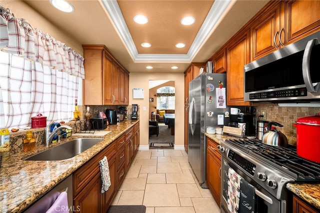 9228 Whiting Way, Riverside, CA 92508 - kitchen featuring stainless steel appliances, a tray ceiling, brown cabinets, crown molding, and recessed lighting
