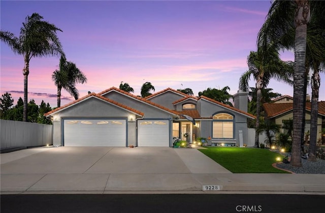 9228 Whiting Way, Riverside, CA 92508 - mediterranean / spanish-style home featuring an attached garage, concrete driveway, a tile roof, and stucco siding