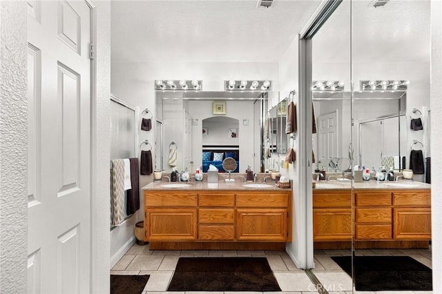9228 Whiting Way, Riverside, CA 92508 - bathroom with tile patterned floors, double vanity, a shower stall, ensuite bath, and a textured ceiling