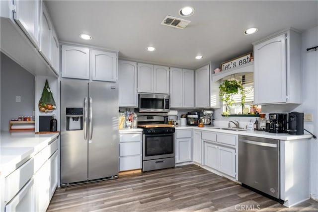 28521 Williams Dr, Menifee, CA 92587 - kitchen with stainless steel appliances, light countertops, recessed lighting, wood finished floors, and white cabinets
