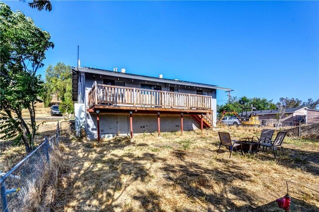 28521 Williams Dr, Menifee, CA 92587 - back of property with stairs, a wooden deck, a fenced backyard, and a fire pit