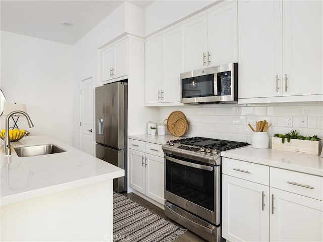 1673 Lexington Ln, San Pedro, CA 90732 - kitchen with appliances with stainless steel finishes, white cabinetry, tasteful backsplash, dark wood-type flooring, and light stone counters