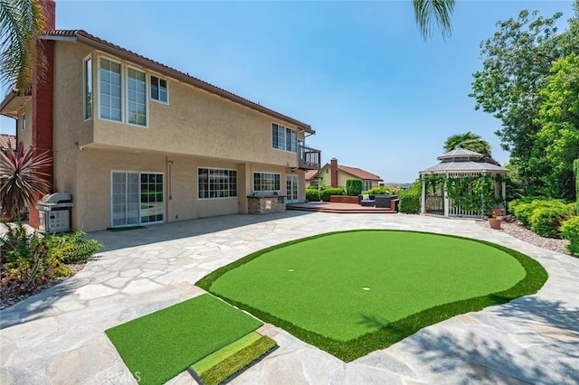 21557 Ambushers St, Diamond Bar, CA 91765 - rear view of house featuring a putting green, stucco siding, a patio area, a gazebo, and a balcony