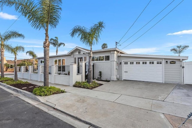 4704 Jumano Ave, San Diego, CA 92117 - view of front of house featuring a fenced front yard, concrete driveway, an attached garage, a gate, and stucco siding