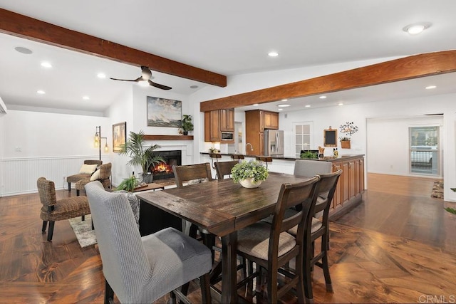 4704 Jumano Ave, San Diego, CA 92117 - dining room featuring a lit fireplace, a ceiling fan, recessed lighting, and wainscoting