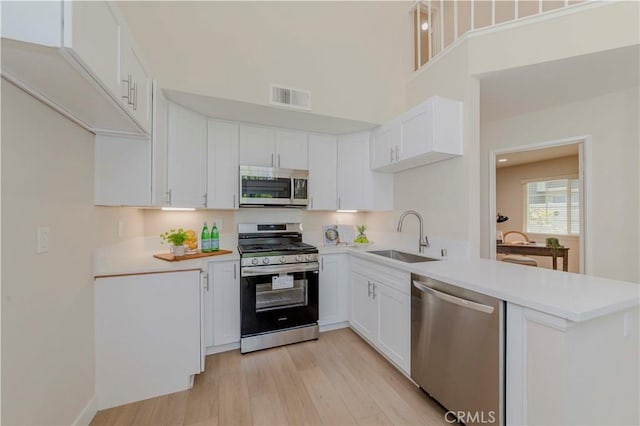 20759 E Crest Ln Unit B, Walnut, CA 91789 - kitchen with stainless steel appliances, a peninsula, white cabinetry, light countertops, and a high ceiling