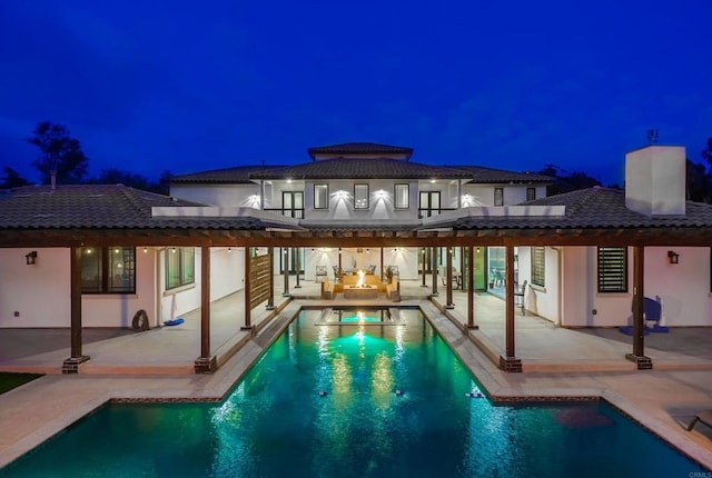 2184 Pacific Crest Dr, Alpine, CA 91901 - back of house at night with a patio, an outdoor pool, stucco siding, and a hot tub