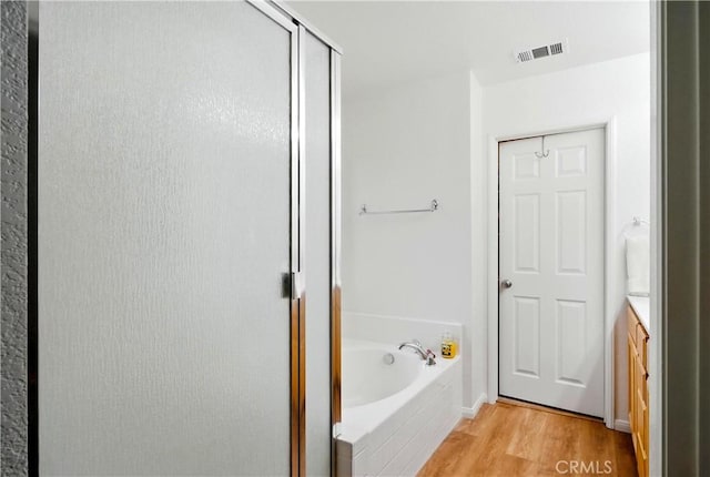 6257 Long Cove Dr, Fontana, CA 92336 - bathroom with wood finished floors, a garden tub, a shower stall, and vanity