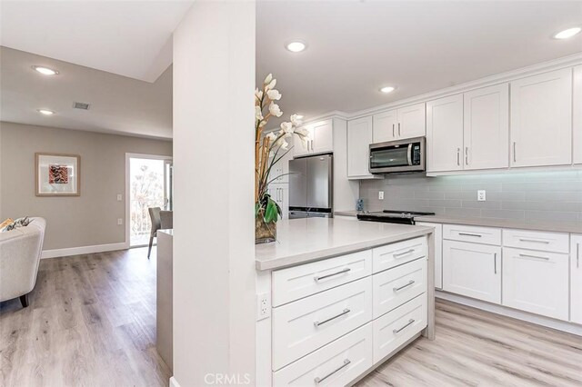 4014 Calle Sonora Oeste Unit 2B, Laguna Woods, CA 92637 - kitchen featuring appliances with stainless steel finishes, backsplash, light countertops, light wood-type flooring, and white cabinets