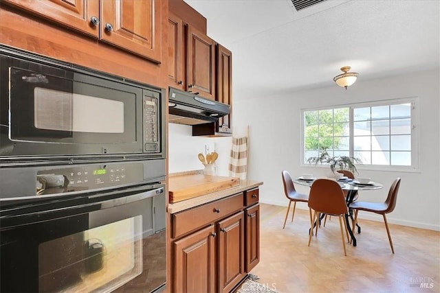 367 E Pacific Ave, Fairfield, CA 94533 - kitchen with black appliances, brown cabinets, under cabinet range hood, and light countertops