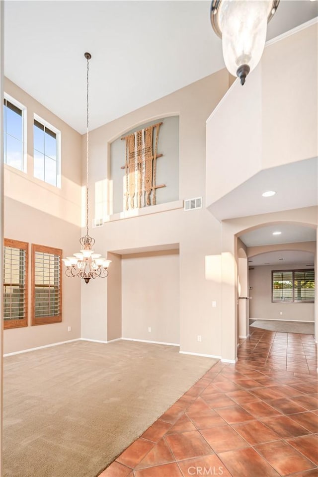 40028 Bluff Ct, Palmdale, CA 93551 - unfurnished living room featuring a towering ceiling, plenty of natural light, a chandelier, and tile patterned flooring