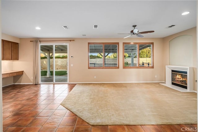 40028 Bluff Ct, Palmdale, CA 93551 - unfurnished living room with ceiling fan, a glass covered fireplace, recessed lighting, and a desk