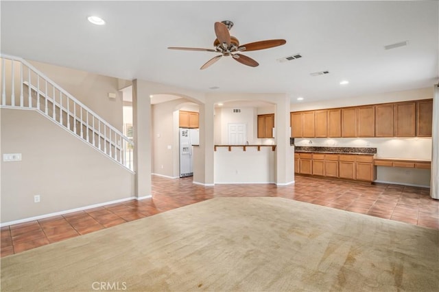 40028 Bluff Ct, Palmdale, CA 93551 - kitchen featuring white fridge with ice dispenser, light tile patterned floors, ceiling fan, arched walkways, and recessed lighting