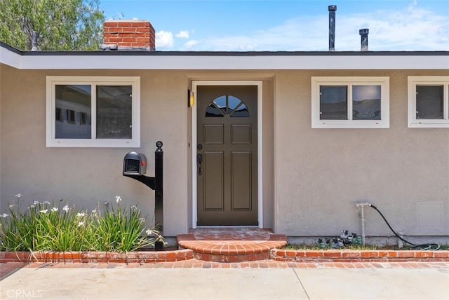 2323 Colgate Dr, Costa Mesa, CA 92626 - view of exterior entry featuring stucco siding and a chimney