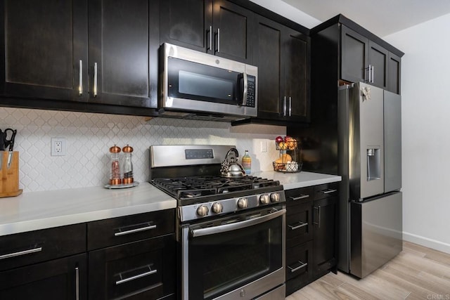 4336 Harbor Way Unit 1, Oceanside, CA 92056 - kitchen featuring stainless steel appliances, light countertops, decorative backsplash, light wood-type flooring, and dark cabinetry