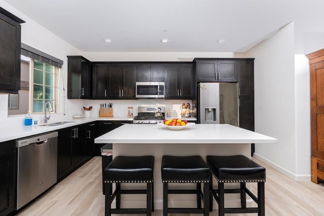 4336 Harbor Way Unit 1, Oceanside, CA 92056 - kitchen featuring appliances with stainless steel finishes, a kitchen bar, light wood-style flooring, and recessed lighting