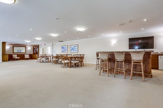 240 Nice Ln Unit 114, Newport Beach, CA 92663 - dining room with a dry bar, crown molding, light carpet, arched walkways, and recessed lighting