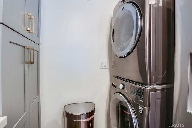 240 Nice Ln Unit 114, Newport Beach, CA 92663 - laundry room featuring estacked washer and dryer and cabinet space