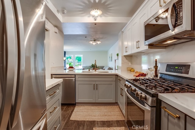 240 Nice Ln Unit 114, Newport Beach, CA 92663 - kitchen with appliances with stainless steel finishes, light countertops, dark wood-style floors, gray cabinetry, and white cabinets