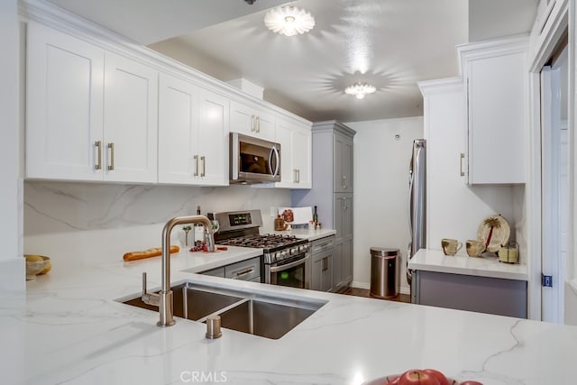 240 Nice Ln Unit 114, Newport Beach, CA 92663 - kitchen with appliances with stainless steel finishes, light stone countertops, white cabinets, and gray cabinets