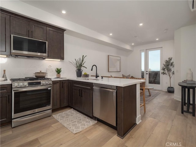 402 W Grand Ave Unit 101, Grover Beach, CA 93433 - kitchen with appliances with stainless steel finishes, a peninsula, dark brown cabinetry, light countertops, and recessed lighting