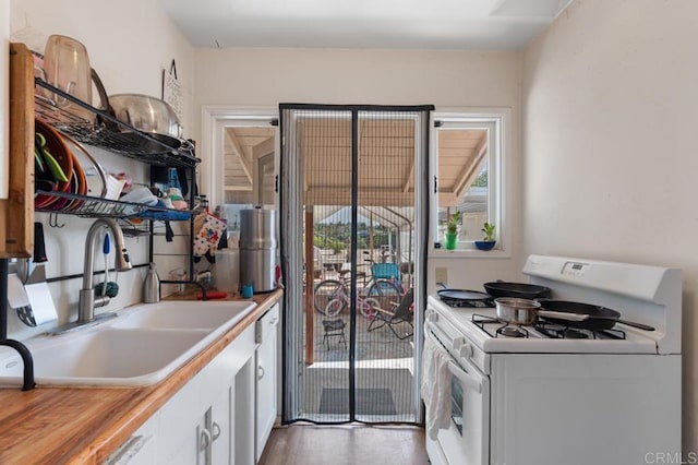 1185 Elm Ave, Chula Vista, CA 91911 - kitchen with white gas range oven, white cabinets, and wood finished floors