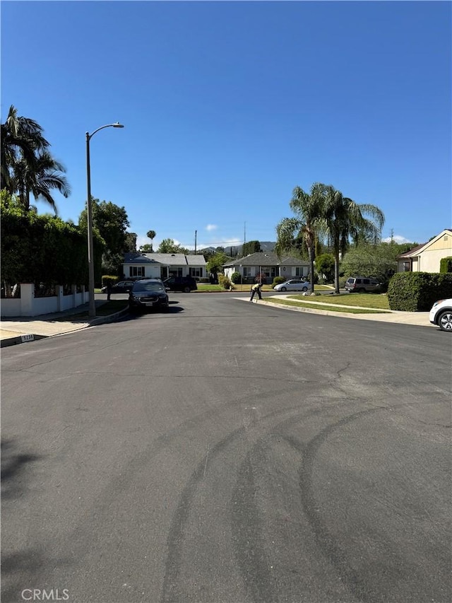 5230 Seville Ave, Encino, CA 91436 - view of asphalt road featuring street lights, curbs, a residential view, and sidewalks
