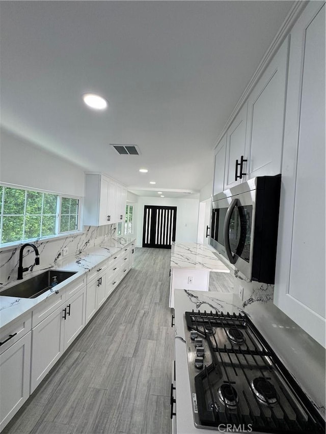 5230 Seville Ave, Encino, CA 91436 - kitchen with stainless steel appliances, white cabinets, backsplash, light stone counters, and recessed lighting