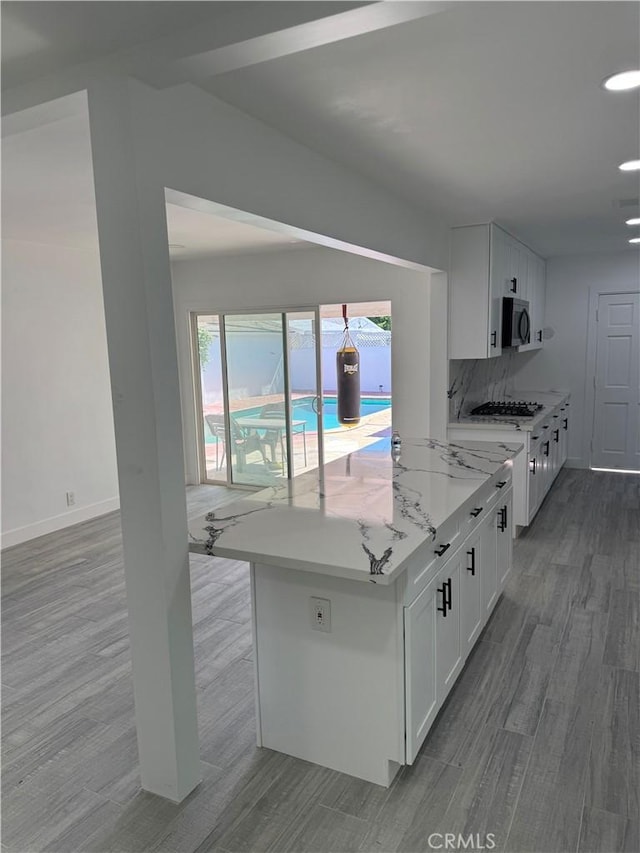 5230 Seville Ave, Encino, CA 91436 - kitchen featuring stainless steel microwave, white cabinets, dark wood-type flooring, and healthy amount of natural light