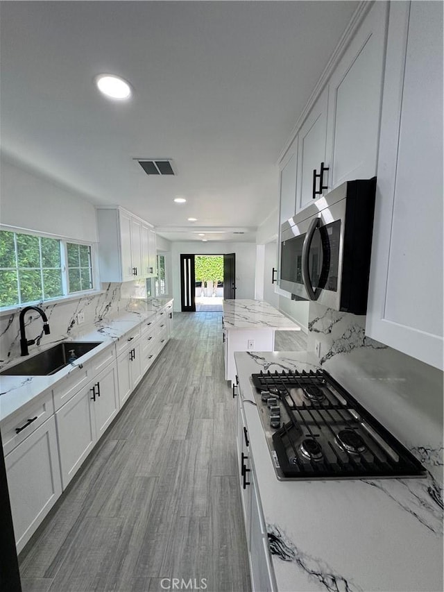 5230 Seville Ave, Encino, CA 91436 - kitchen featuring appliances with stainless steel finishes, white cabinets, decorative backsplash, recessed lighting, and light stone counters
