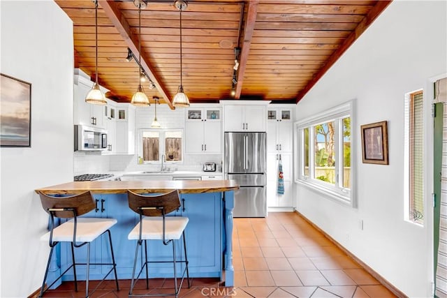 24932 La Cresta Dr, Dana Point, CA 92629 - kitchen featuring stainless steel appliances, a wooden ceiling with exposed beams, a kitchen bar, track lighting, and a peninsula