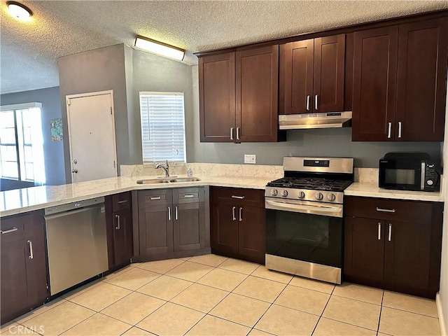 983 Orchard Ln, Colton, CA 92324 - kitchen with appliances with stainless steel finishes, under cabinet range hood, a textured ceiling, dark brown cabinets, and light tile patterned floors