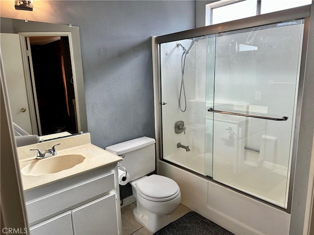 983 Orchard Ln, Colton, CA 92324 - full bath featuring a textured wall, vanity, tile patterned flooring, and combined bath / shower with glass door