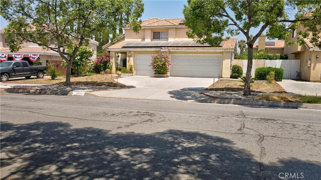 1808 Cave St, Redlands, CA 92374 - view of front facade featuring stucco siding, concrete driveway, solar panels, and a tiled roof