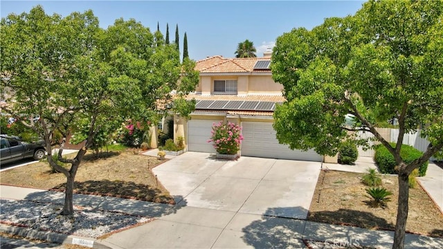 1808 Cave St, Redlands, CA 92374 - view of front of house featuring solar panels, a tile roof, stucco siding, driveway, and a garage