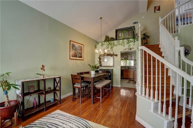 1808 Cave St, Redlands, CA 92374 - dining space with wood finished floors, a chandelier, stairs, and high vaulted ceiling