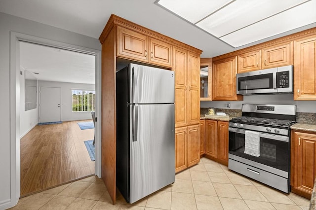 4265 Spoon Bill Way, Oceanside, CA 92057 - kitchen with appliances with stainless steel finishes, brown cabinetry, and light tile patterned floors