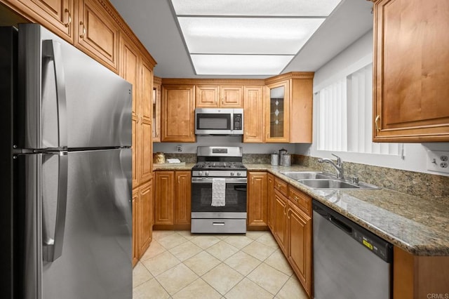 4265 Spoon Bill Way, Oceanside, CA 92057 - kitchen with stainless steel appliances, light tile patterned floors, brown cabinets, glass insert cabinets, and stone counters