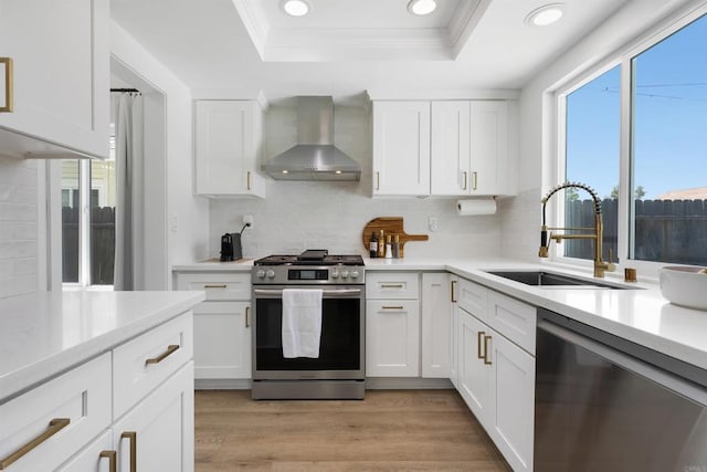 4576 Mariners Bay, Oceanside, CA 92057 - kitchen with stainless steel appliances, wall chimney exhaust hood, a tray ceiling, tasteful backsplash, and recessed lighting