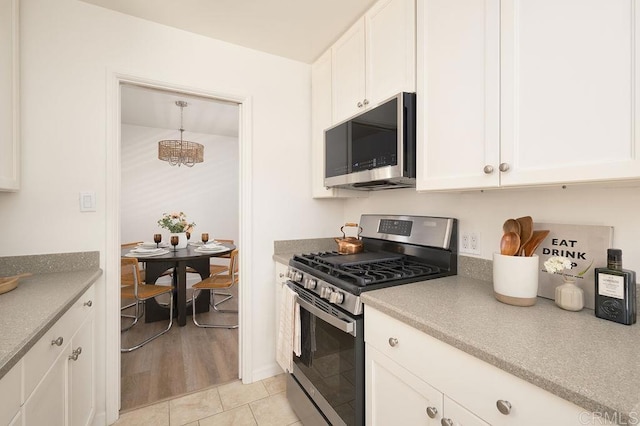 1713 Stewart St, Oceanside, CA 92054 - kitchen featuring stainless steel appliances, white cabinetry, a chandelier, and light tile patterned floors