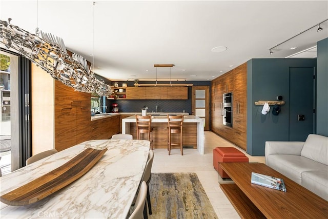 5429 E The Toledo, Long Beach, CA 90803 - kitchen featuring open shelves, light countertops, stainless steel double oven, a kitchen breakfast bar, and decorative backsplash