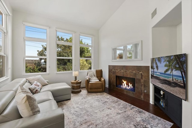 6774 Caurina Ct, Carlsbad, CA 92011 - living area featuring a tiled fireplace, dark wood-style floors, and high vaulted ceiling